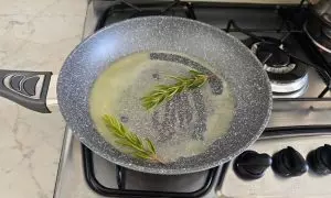 burro sciolto in padella con un rametto di rosmarino